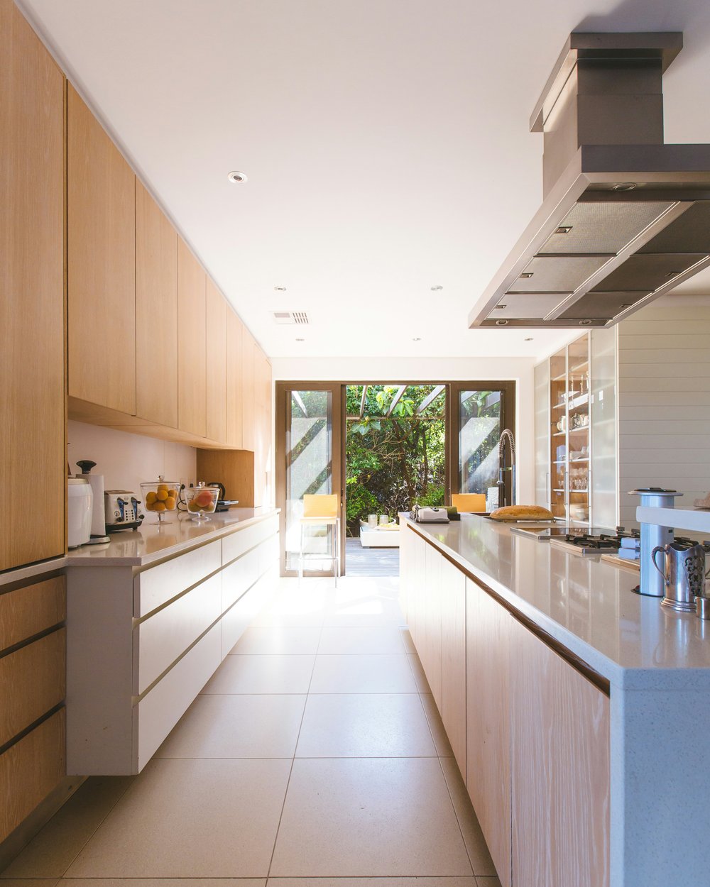 A renovated coastal kitchen with pale cabinetry and marble worktops