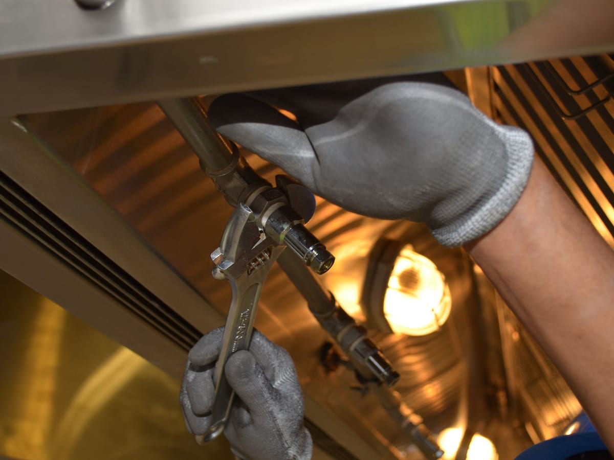 A kitchen tap and pipework being fitted with hand tools