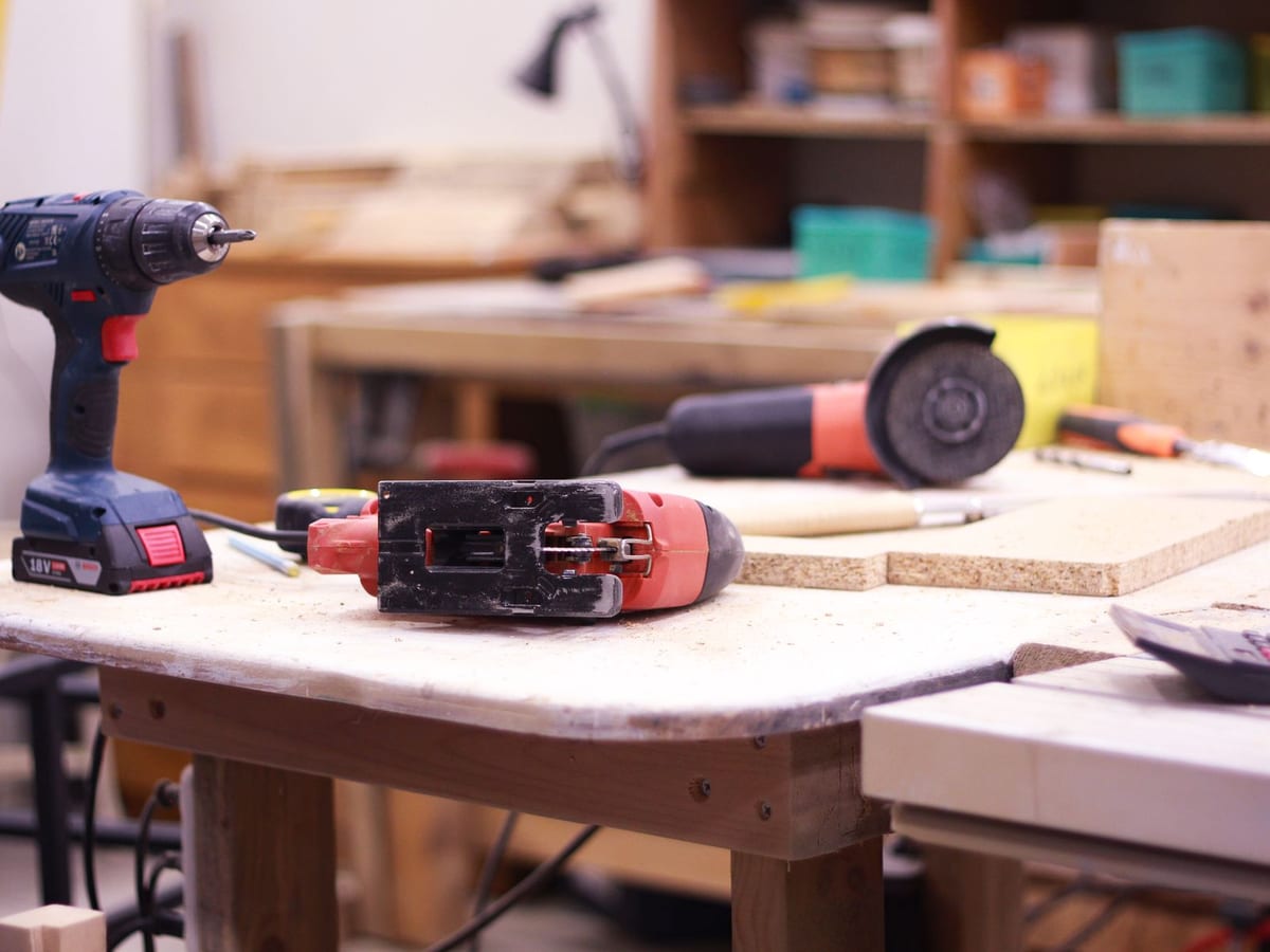 A workshop bench with clamps, power tools, and storage